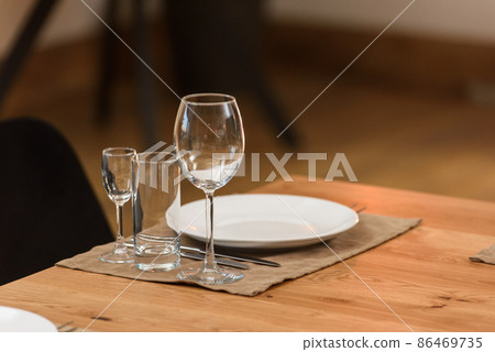 Glass dishes on a wooden table. clean and empty. cozy atmosphere. serving a banquet Glass dishes on a wooden table. clean and empty. cozy atmosphere. serving a banquet 86469735