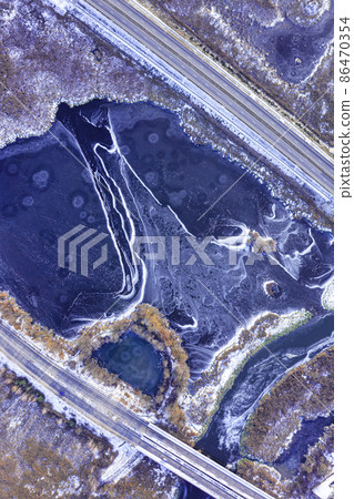 Aerial view on a frozen lake between countryside road highway in winter 86470354