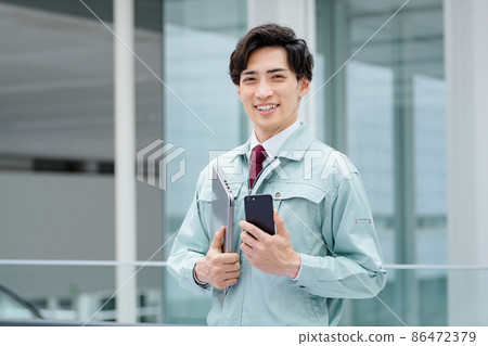 Work clothes engineer who operates a smartphone working in the office 86472379