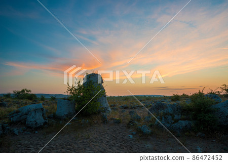 Beautyful sunrise over The Stone Desert Pobiti Kamani - fabulous rock phenomenon in Varna Province, Bulgaria - tourist destination 86472452