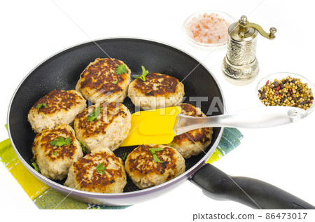 Pan with fried meat patties on white plate 86473017