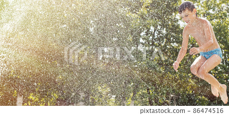 boy jumping into the swimming pool in the garden at summer boy jumping into the swimming pool in the garden at summer 86474516