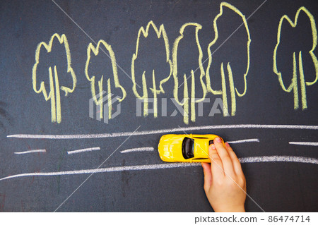 child playing with the car close. one small car goes on the road child playing with the car close. one small car goes on the road 86474714