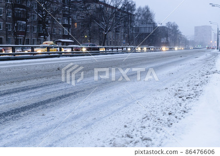 empty snow-covered city road in blue winter dusk empty snow-covered city road in blue winter dusk 86476606