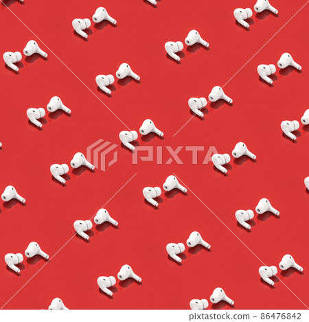 white earphones on a red background. white earphones on a red background. 86476842