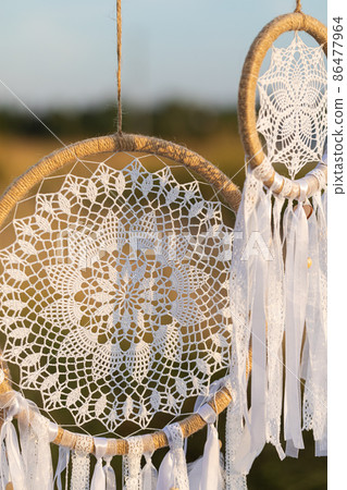 White cotton dreamcatcher at natural background, soft selective focus, toned White cotton dreamcatcher at natural background, soft selective focus, toned 86477964