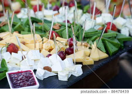 Cheese plate with variety of appetizers on table 86478439