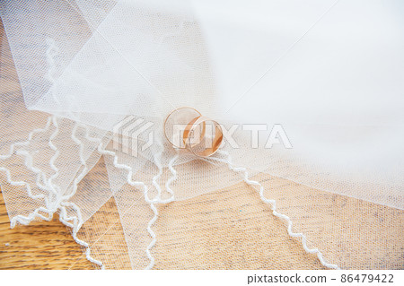 Gold wedding rings on white veil Gold wedding rings on white veil 86479422