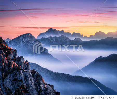 Mountains in fog at beautiful sunset in autumn in Dolomites, Italy. 86479788