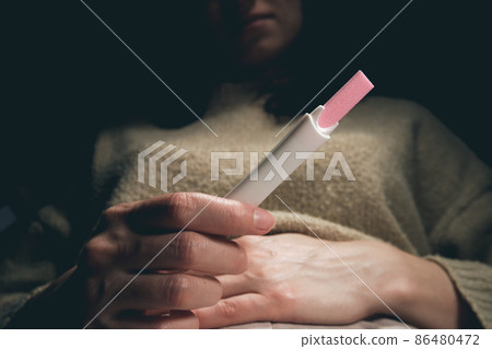 A woman sees a positive pregnancy test result. 86480472