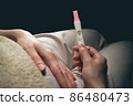 A woman sees a positive pregnancy test result. 86480473