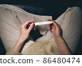 A woman sees a positive pregnancy test result. 86480474