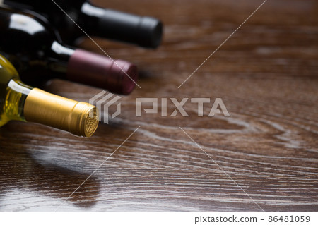Various Wine Bottles on a Reflective Wood Surface Abstract. Various Wine Bottles on a Reflective Wood Surface Abstract. 86481059