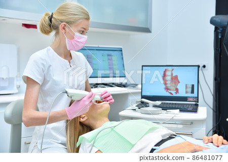 Orthodontist scaning patient with dental intraoral scanner 86481077