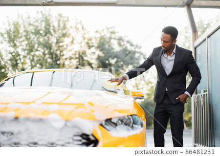 Horizontal view of car cleaning at self wash service outdoors. Horizontal view of car cleaning at self wash service outdoors. 86481231