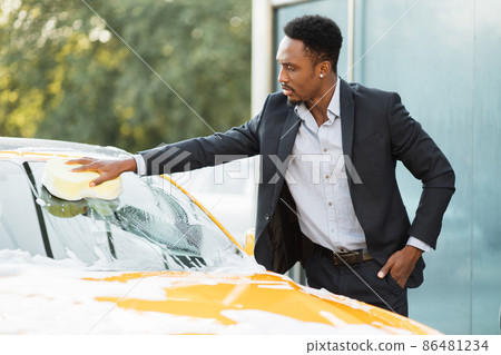 Horizontal view of car cleaning at self wash service outdoors. Horizontal view of car cleaning at self wash service outdoors. 86481234