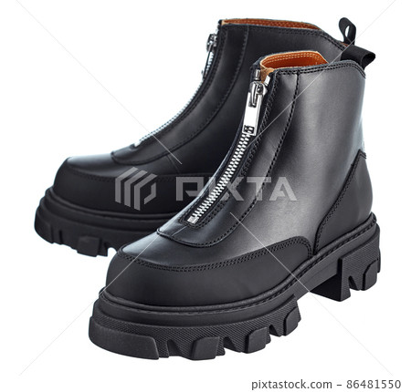 Beautiful pair of high black demi-season leather zippered boots with a massive sole, isolated on a white background. 86481550