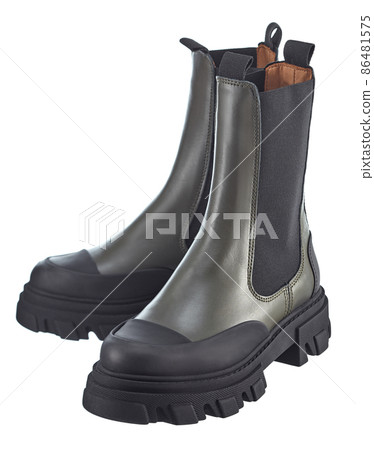 Beautiful pair of high dark-green demi-season leather boots with an elastic band with a massive sole, isolated on a white background.  86481575