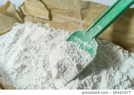 White putty in an open paper bag. Finishing dry powder for leveling walls and ceilings. Repair in the house with your own hands. DIY. Selective focus 86482477