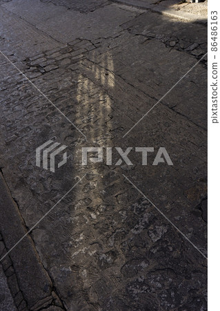 光影照亮了雕刻歷史的鵝卵石街道，西班牙，托萊多 86486163