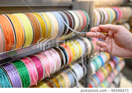 Male hand choosing Ric Rac ribbon in craft shop Male hand choosing Ric Rac ribbon in craft shop 86486871