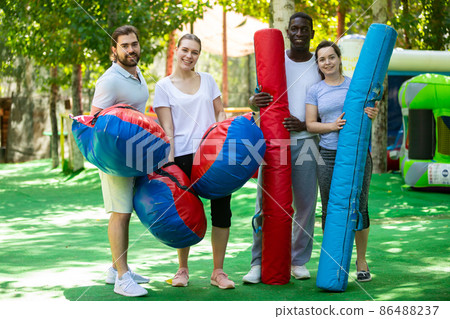Cheerful people in outdoor inflatable amusement park 86488237