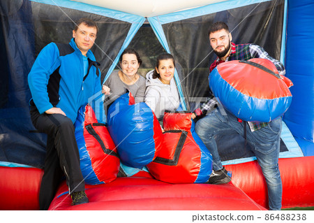 Friends standing near inflatable ring Friends standing near inflatable ring 86488238