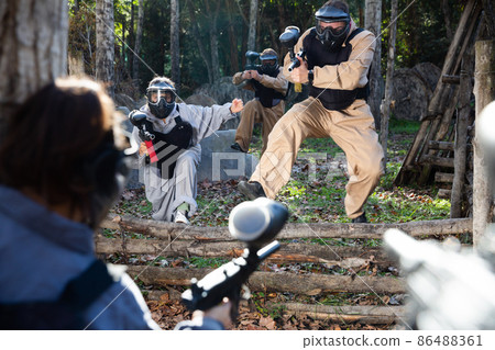 Men and women playing paintball 86488361