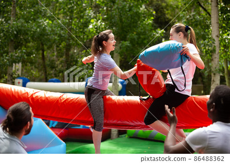 Pillow fight between girlfriends in an amusement park Pillow fight between girlfriends in an amusement park 86488362