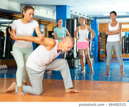 Latin american woman mastering hammerlock while sparring with man in self defence training 86488535