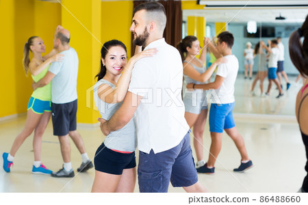 sporty girls and men learning salsa steps 86488660