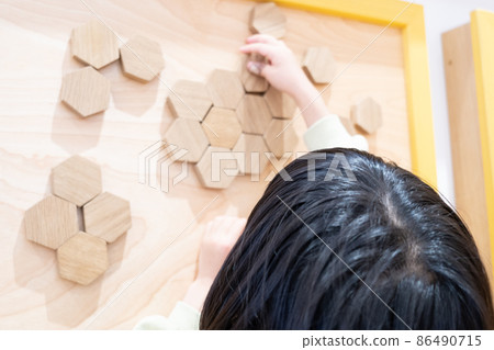 一個女孩在木牆上玩大玩具工藝品 86490715