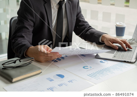 The businessman hand sits at their desks and calculates financial graphs showing the results of their investments planning the process of successful business growth 86491074