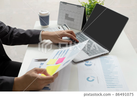 The businessman hand sits at their desks and calculates financial graphs showing the results of their investments planning the process of successful business growth 86491075