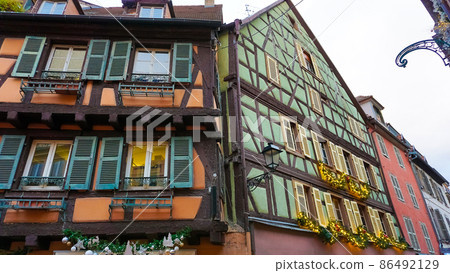 Colmar, Petit Venice, narrow street and traditional half timbered colorful houses at winter with christmas decorations . Alsace, France. Colmar, Petit Venice, narrow street and traditional half timbered colorful houses at winter with christmas decorations . Alsace, France. 86492129