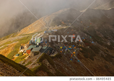黃昏時分,南阿爾卑斯山北嶽山脊的肩部小屋的帳篷地面 黃昏時分,南阿爾卑斯山北嶽山脊的肩部小屋的帳篷地面 86495485