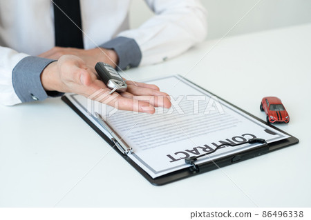Car dealer businessman holding a car key. Car loan and insurance concept 86496338