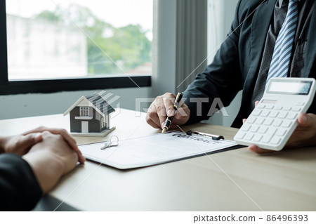 A real estate agent with House model is talking to clients about buying home insurance. Home insurance concept 86496393