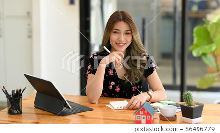 Female real estate realtor or house insurance broker sitting at her office. Female real estate realtor or house insurance broker sitting at her office. 86496779