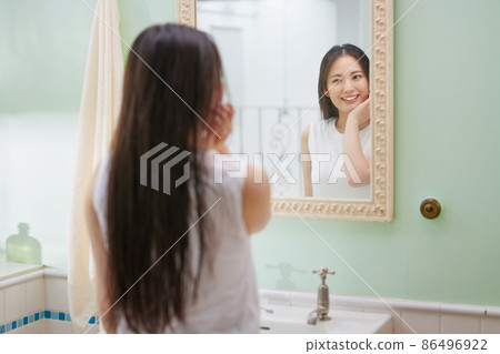 做頭髮護理的長頭髮的年輕女人 做頭髮護理的長頭髮的年輕女人 86496922