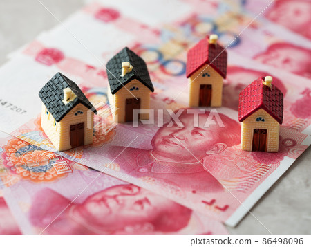Chinese yuan banknotes and miniature figures of houses Real estate image 86498096
