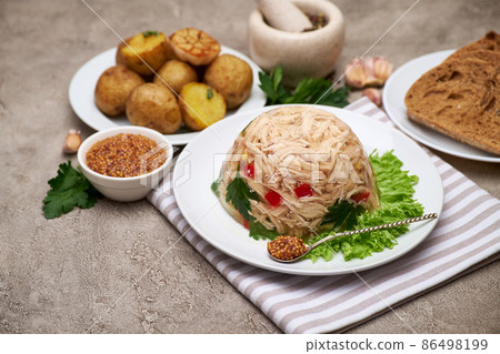 Delicious chicken aspic on a plate on concrete table Delicious chicken aspic on a plate on concrete table 86498199