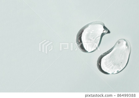 Transparent hyaluronic acid gel drop on a gray background. Transparent hyaluronic acid gel drop on a gray background. 86499388