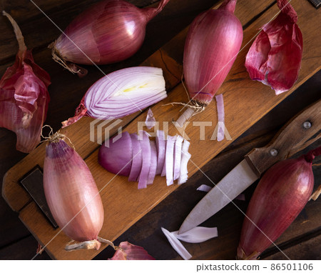 Sliced Red tropea onions with a knife on a wooden board top view Sliced Red tropea onions with a knife on a wooden board top view 86501106