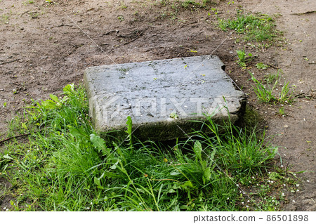 A large stone on grass and sand A large stone on grass and sand 86501898