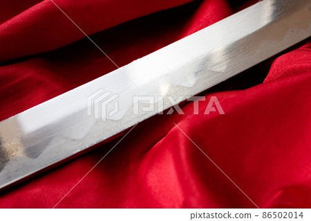 Samurai sword on the red cloth closeup Samurai sword on the red cloth closeup 86502014