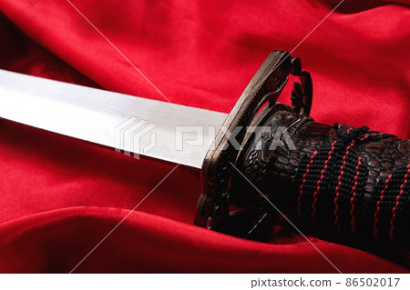 Samurai sword on the red cloth closeup Samurai sword on the red cloth closeup 86502017