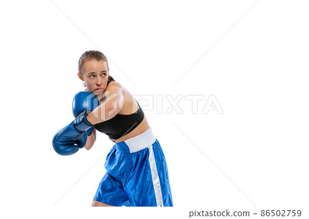 In action, motion. Young girl, professional boxer practicing in boxing gloves isolated on white studio background. Concept of sport, studying, competition 86502759