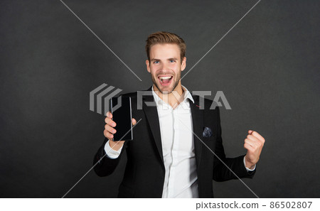 Be in to win. Happy businessman hold cellphone making winning gesture. Win smartphone 86502807