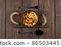 plate of wok noodles on a wooden surface. Top view. delicious Chinese pasta with shrimp and spices. dish of shrimp  86503445